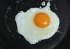 A wife was making a breakfast of fried eggs for her husband.