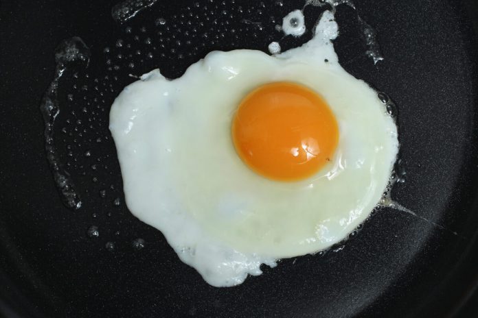 A wife was making a breakfast of fried eggs for her husband.